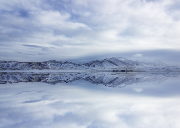 积云下的藏区雪山与湖面倒影，中国西藏