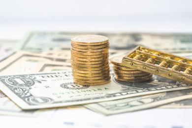 金色的硬币和算盘放在美金上