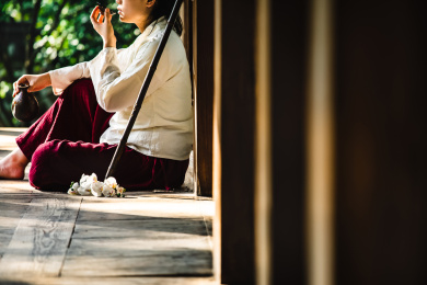 身着汉服女子坐在古代中式房子阳台上拿着酒杯酒壶喝酒旁边放着一把洞箫