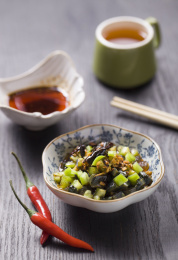 放在深色餐布上的一盘中国传统家常凉拌菜 —  尖椒皮蛋