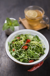 放在深色餐布上的一碗中国传统家常凉拌菜 — 捞汁香椿奶白菜