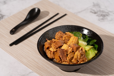 餐垫上黑色陶瓷碗里的支竹牛腩饭