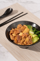 餐垫上黑色陶瓷碗里的支竹牛腩饭