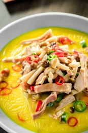 一碗金黄色的猪肚炖草菇鸡汤煲