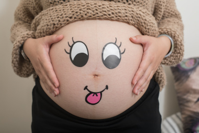 怀孕的孕妇露出了自己的大肚子