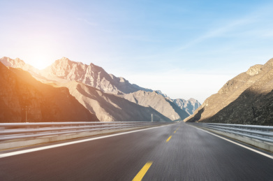 夕阳下一条动感柏油路贯穿于峻峭的峡谷间