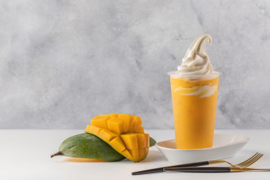 灰色背景上的鲜榨芒果汁饮品