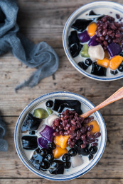 木制餐桌上摆着两碗糖水甜品中式传统美食小吃古早味芋圆红豆珍珠烧仙草