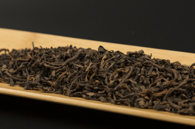 黑色背景里一茶盘颗粒状普洱熟茶散茶