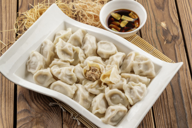 刚出锅的猪肉大葱水饺摆放在木板上