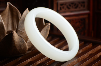 暗调复古中国风里靠在陶瓷莲花上的白色玉手镯
