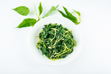 中国潮汕菜蒜蓉炒麻叶在白背景上