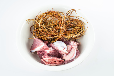 新鲜的猪骨和鸡骨草放在大碗里   