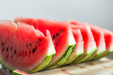 实木桌上被切成片状的甜美多汁的西瓜