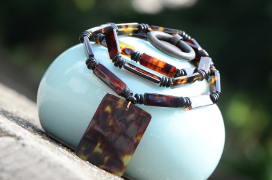 复古背景上的精美雕塑玳瑁花纹吊牌项链特写图片