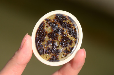 复古虚化背景上的精美雕塑玳瑁花纹吊牌特写图片