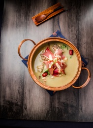 黑色餐布上的一口铜锅火腿炖柴鸡