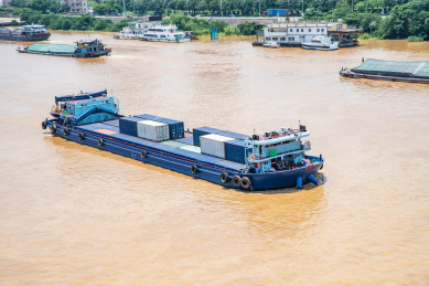 中国广东省佛山潭洲水道河面上航行的一艘集装箱船 