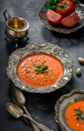 黑色背景上放着用花纹复古餐具装着的番茄汤