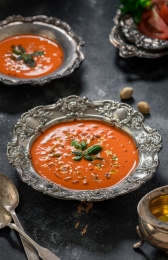 黑色背景上放着用花纹复古餐具装着的番茄汤