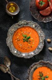 黑色背景上放着用花纹复古餐具装着的番茄汤