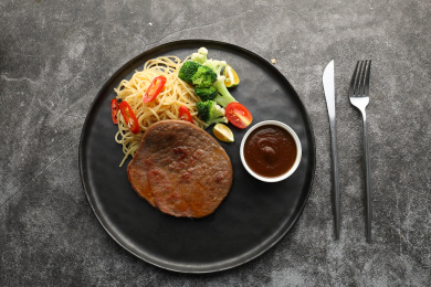 西餐黑色圆盘子里的沙朗牛排意面