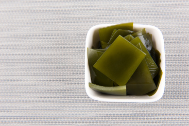 灰色餐垫上白碗里的海带片