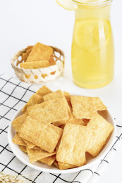 放在白色格子餐布上的小米锅巴和柠檬饮料