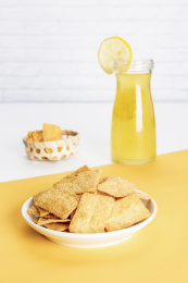 小米锅巴和柠檬饮料放在黄白撞色背景上