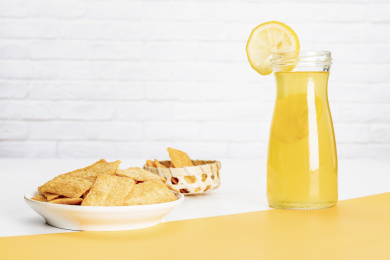 小米锅巴和柠檬饮料放在黄白撞色背景上