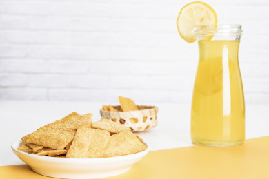 小米锅巴和柠檬饮料放在黄白撞色背景上