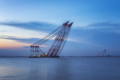 傍晚海面上屹立的船用起重机