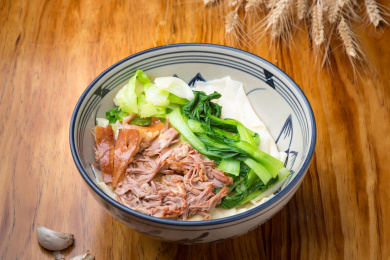 一碗放在木桌上的陕西西腊汁肉油泼面