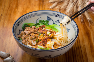 一碗放在木桌上的陕西西腊汁肉油泼面