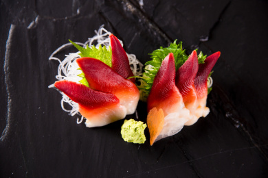 黑色盘子的北极贝刺身日本料理