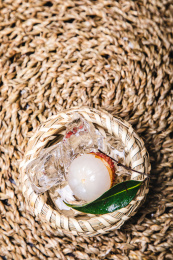 正上方视角特写编织的篮子里装着剥开的新鲜荔枝和冰块