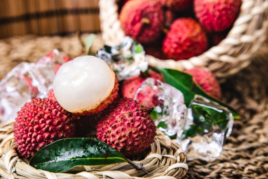 特写编织的水果篮里装满带叶子的新鲜荔枝和冰块