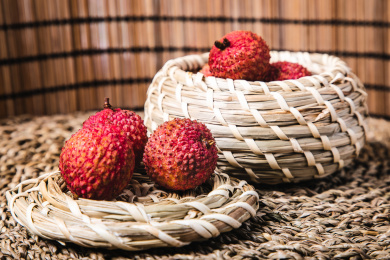 特写编织的篮子里放着多个完整的新鲜荔枝