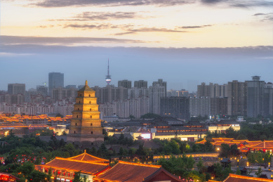 夕阳下的中国西安大雁塔和市区的现代建筑夜景