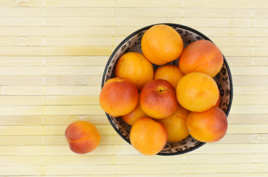 放在竹盖帘上装在小碗里的新鲜的新疆吊干杏特写，俯视