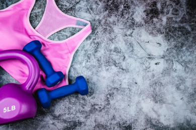 正上方视角特写放在水泥质感地板上的运动内衣，壶铃和哑铃