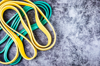 正上方视角特写水泥质感的地板上放着运动拉伸用的弹力绳