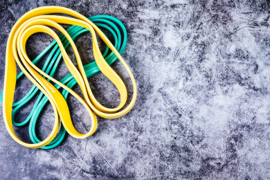 正上方视角特写水泥质感的地板上放着运动拉伸用的弹力绳