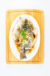 中国粤菜一碟清蒸鲈鱼在白背景上