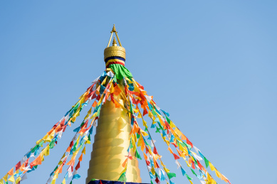 有五彩经幡的金色建筑屋顶和天空