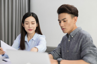 年轻的男员工和女员工在办公室内讨论工作上的相关问题