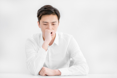 穿白色衬衫坐在办公桌前认真思考的中国年轻男