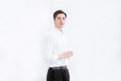 站在办公室里喝水休息的中国年轻男性