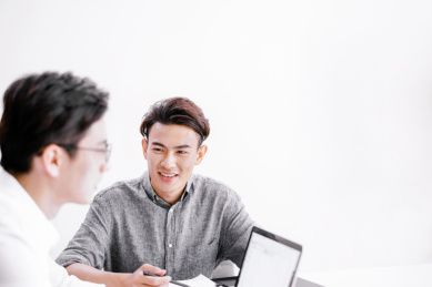 两个坐在办公桌前讨论的年轻男士