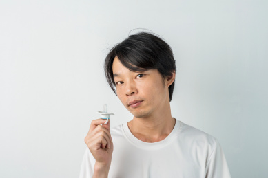 口含安抚奶嘴的白衣成年男子